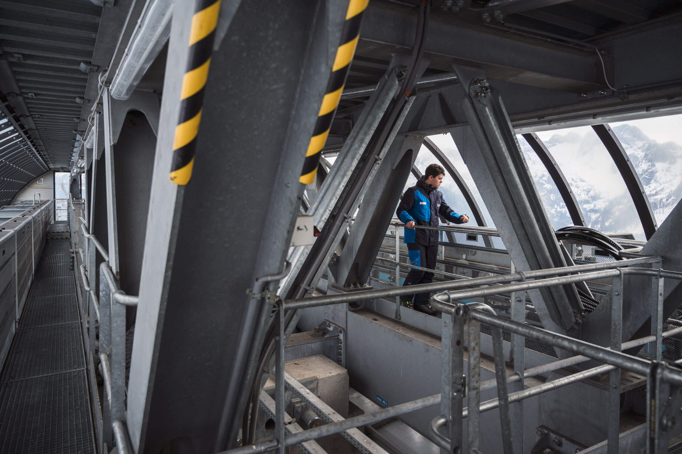 Corporate Fotografie für die Attraktivität des Berufes des Seilbahntechnikers. Der Lehrling inspiziert auf dem Foto gerade die Koppelanlage der Gondelbahn