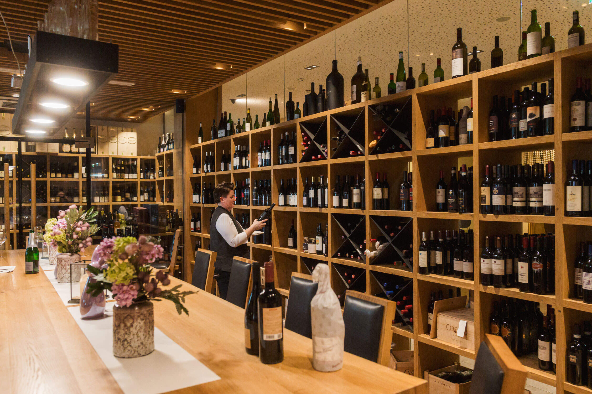 Weinsommelier sucht Flasche im Weinkeller