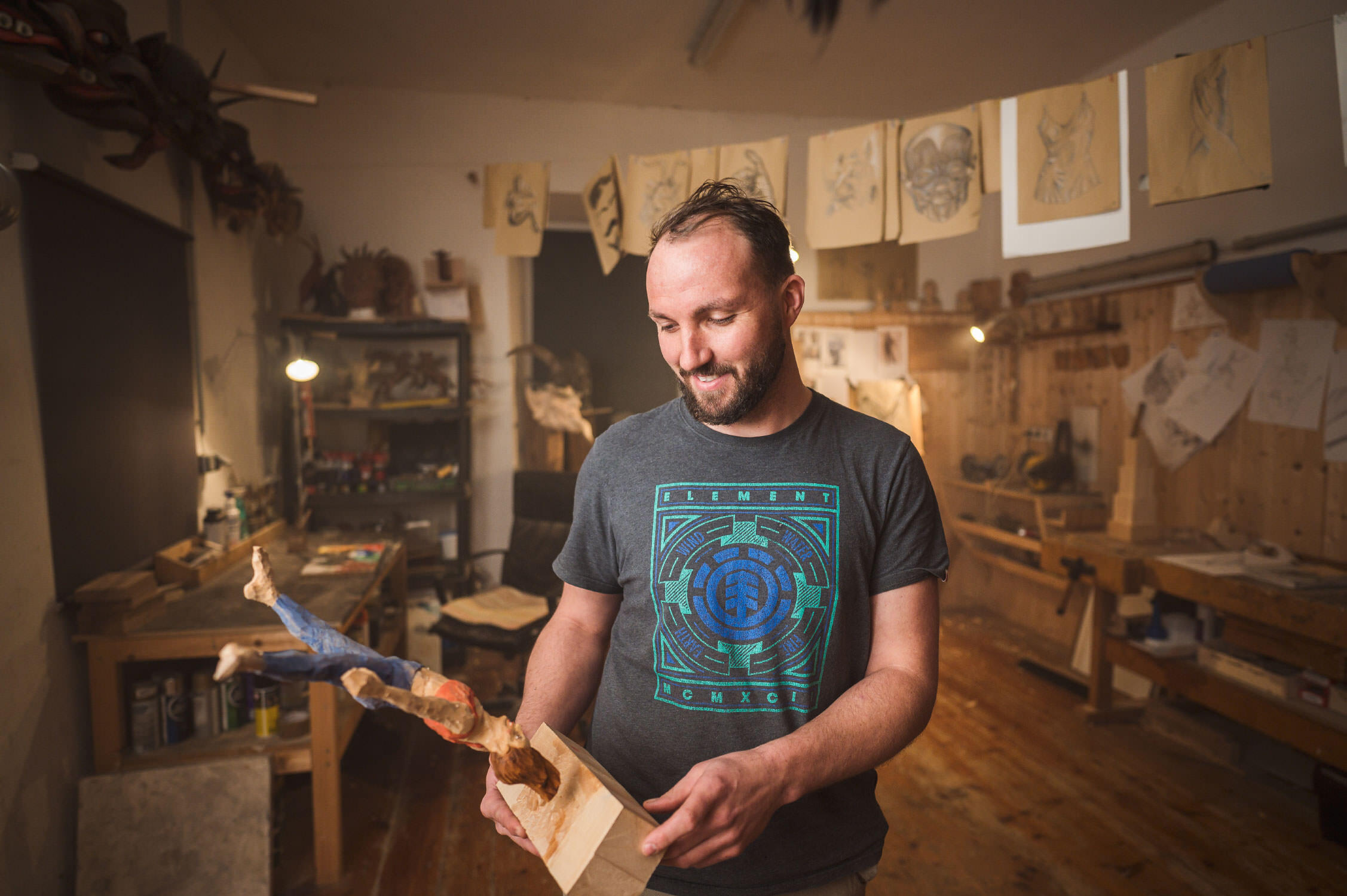 Businessfotografie im Handwerk. Stolz präsentiert der Künstler die geschnitzte Figur